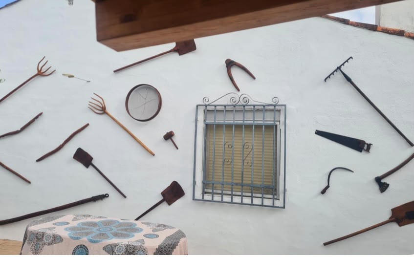 Pared decorada con aperos de labranza tradicionales