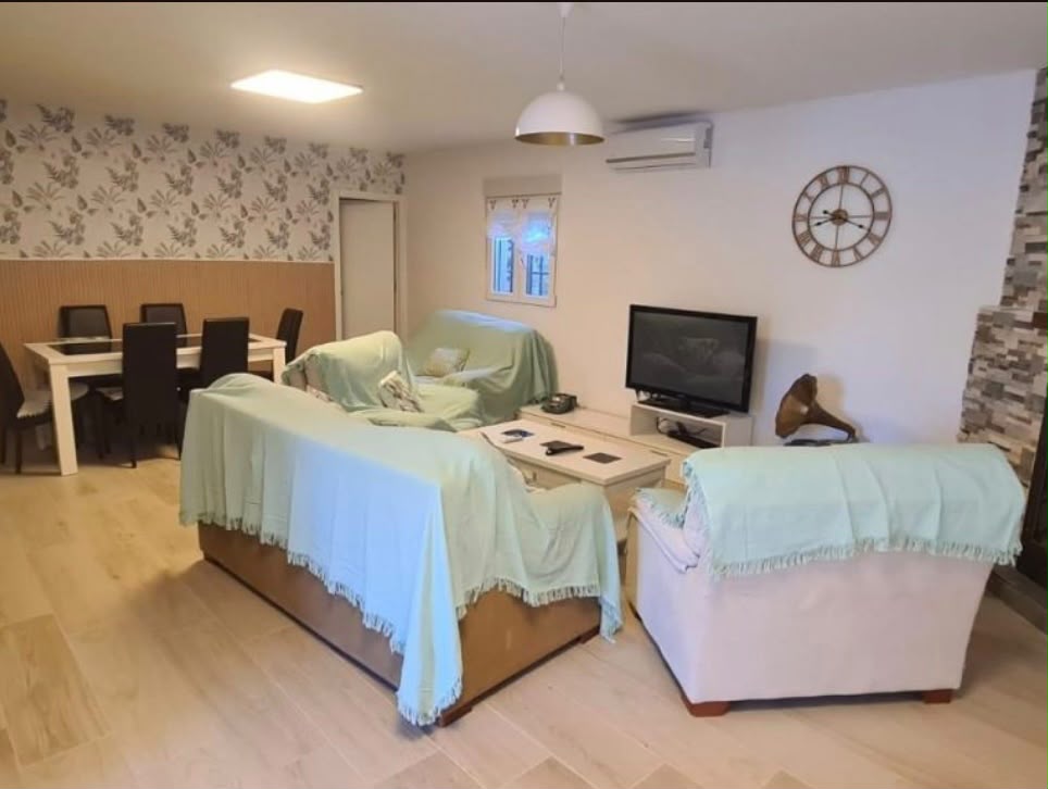 Salón comedor con sofás, televisión y aire acondicionado
