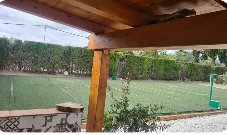Vista de la pista deportiva desde el porche de madera
