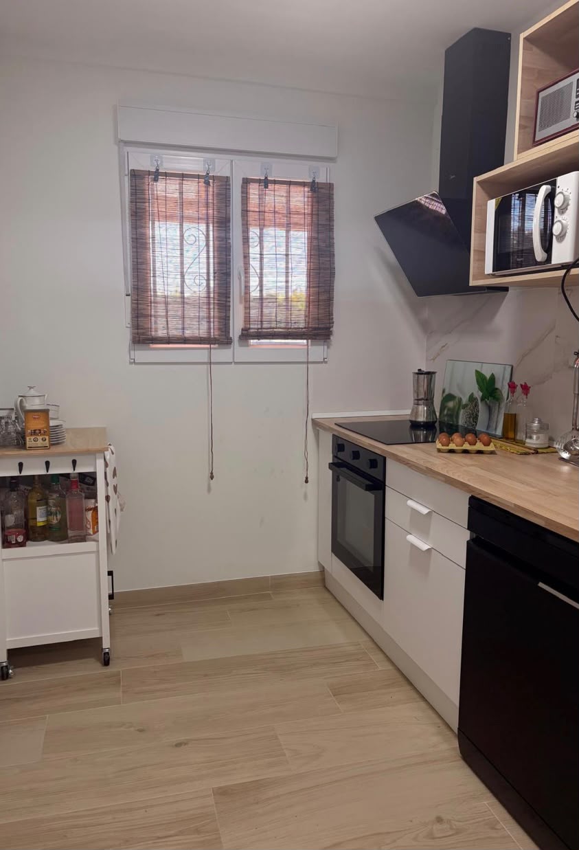 Cocina con microondas, campana y encimera de madera